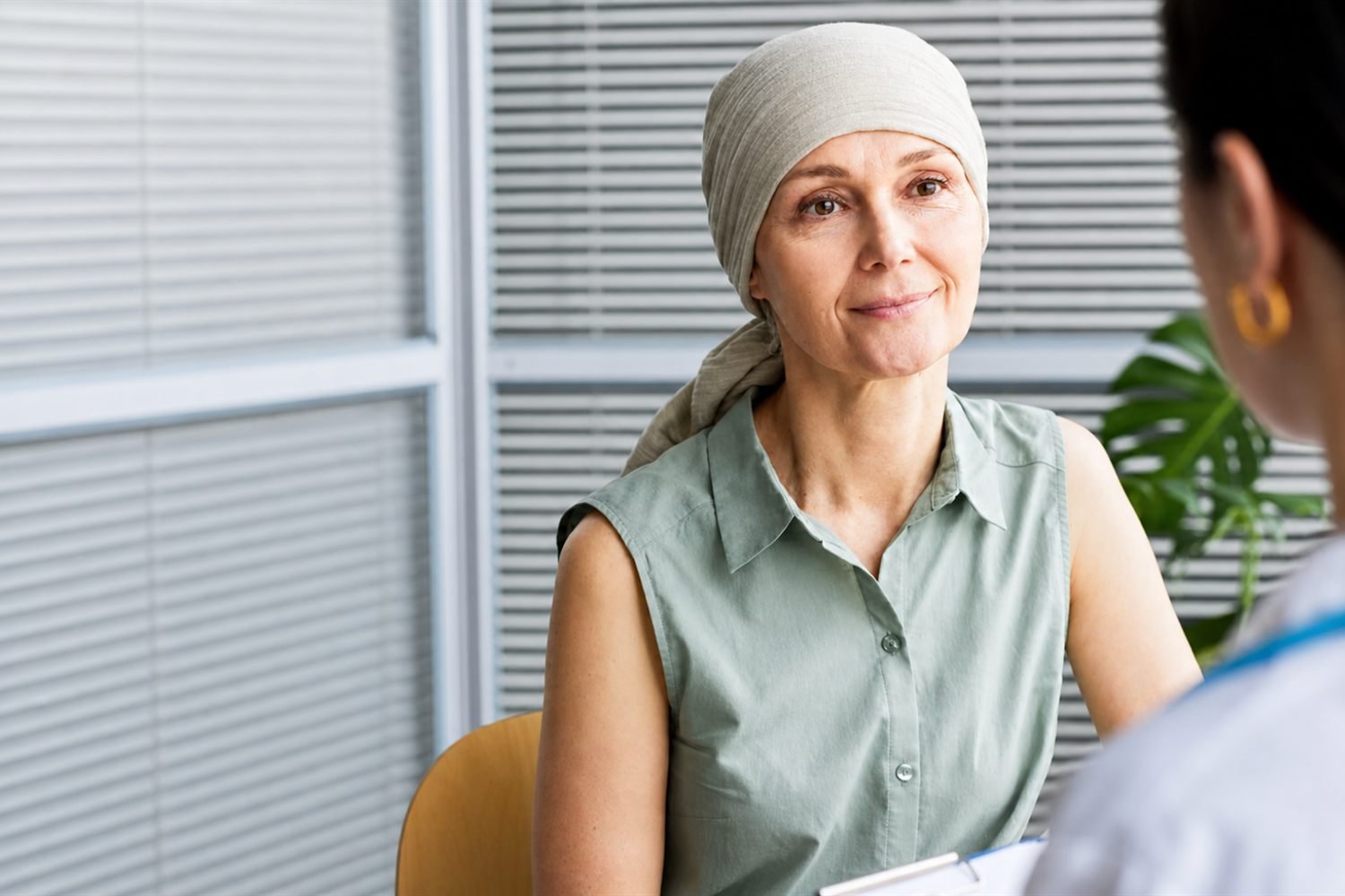 A practitioner leaning in to listen closely to an older patient