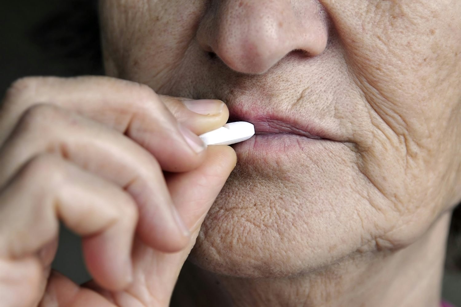 An older person taking a tablet